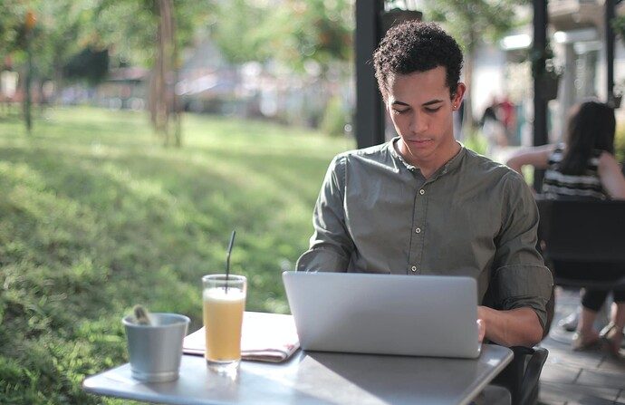 Focused male freelancer using laptop in street cafe (https://www.pexels.com/photo/focused-black-male-freelancer-using-laptop-in-street-cafe-3799115/)