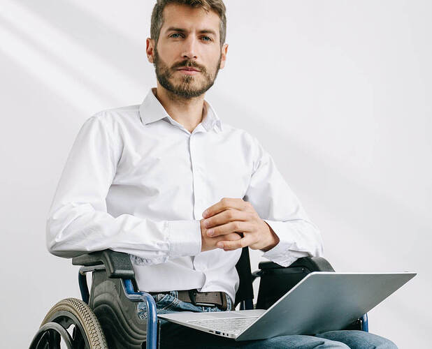 Man Sitting on a Wheelchair with a Laptop on his Lap